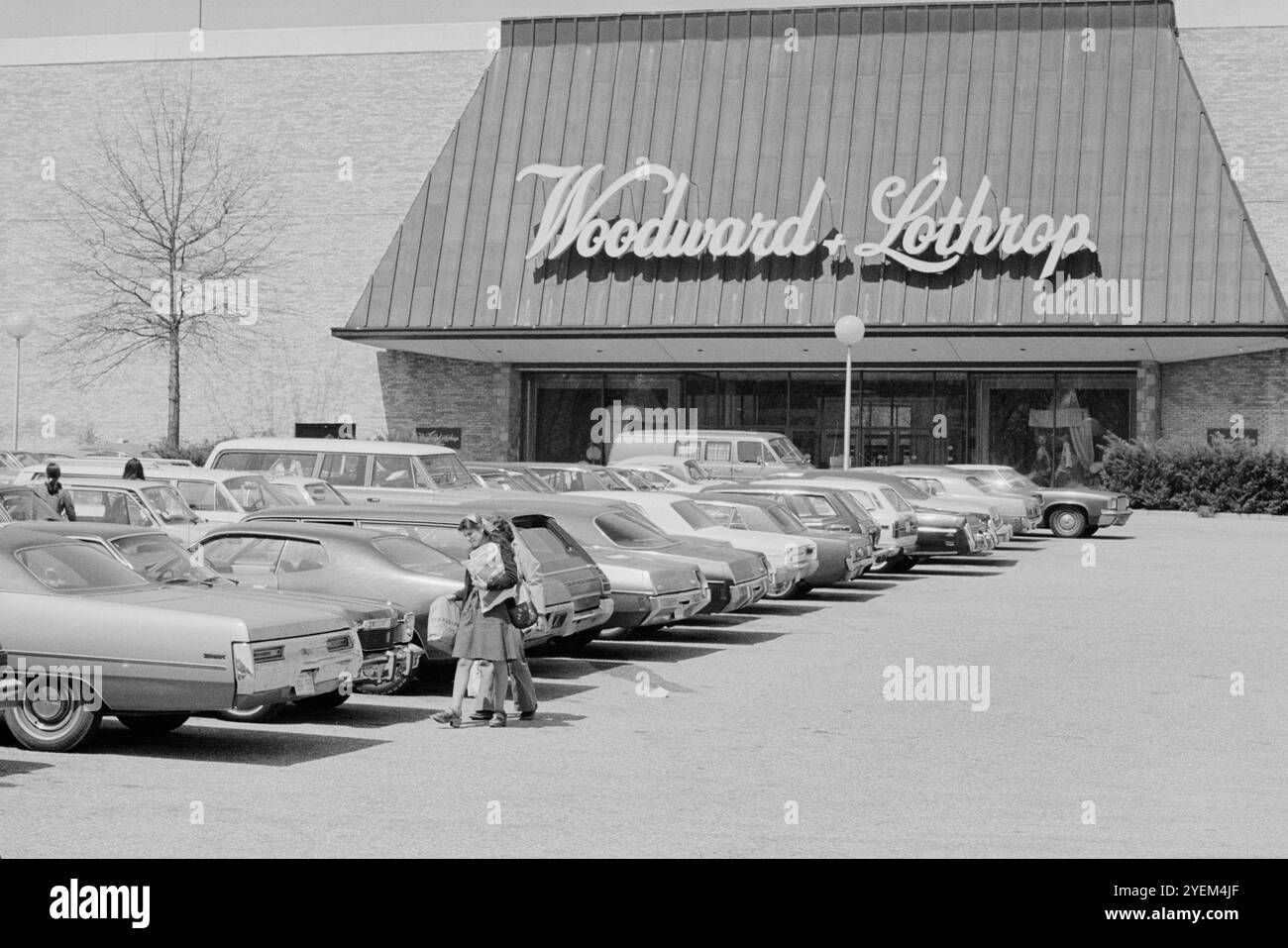 Vintage-Foto von Leuten, die auf einem Parkplatz vor dem Kaufhaus Woodward & Lothrop, Tysons Corner Mall, Tysons Corner, Virginia laufen. USA. 12. April 1976 Stockfoto