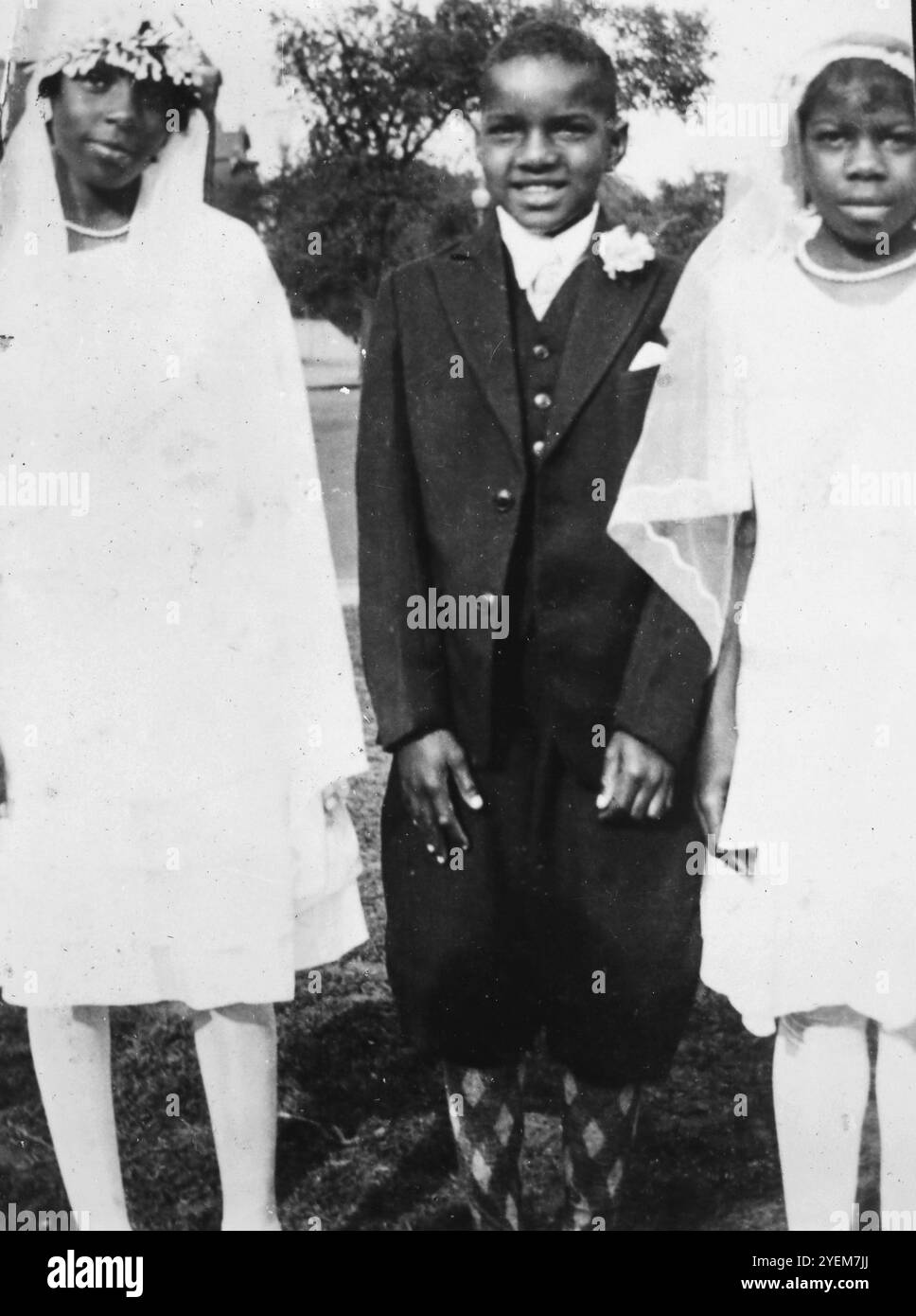 Afroamerikanische Kinder posieren für Fotos nach einer katholischen Erstkommunionzeremonie, ca. 1932. Stockfoto