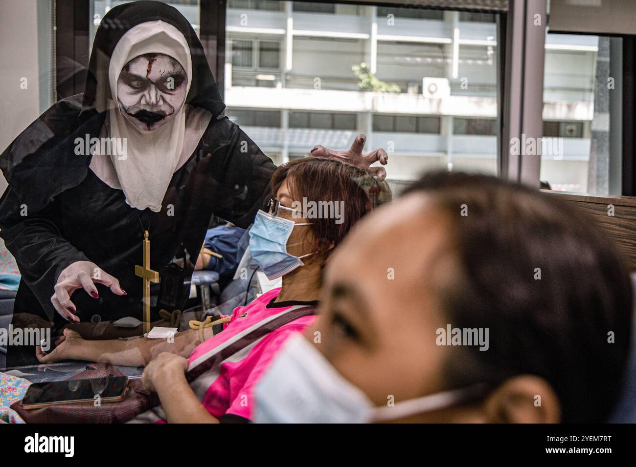 Bangkok, Bangkok, Thailand. 31. Oktober 2024. 31. Oktober 2024, Bangkok, Thailand, Ein Angestellter in einem Geisterkostüm neckt einen Blutspender während einer Halloween-Blutspendefahrt im National Blood Center, Thai Red Cross Society in Bangkok. Die Mitarbeiter des National Blood Center, die in den Geisterkostümen gekleidet waren, um das Halloween-Festival zu feiern, wollten Spender ermutigen, ihr Blut im Rahmen einer blutigen Halloween-Kampagne der Thai Roten Kreuz Society zu spenden. (Kreditbild: © Wissarut Weerasopon/ZUMA Press Wire) NUR REDAKTIONELLE VERWENDUNG! Nicht für kommerzielle ZWECKE! Stockfoto