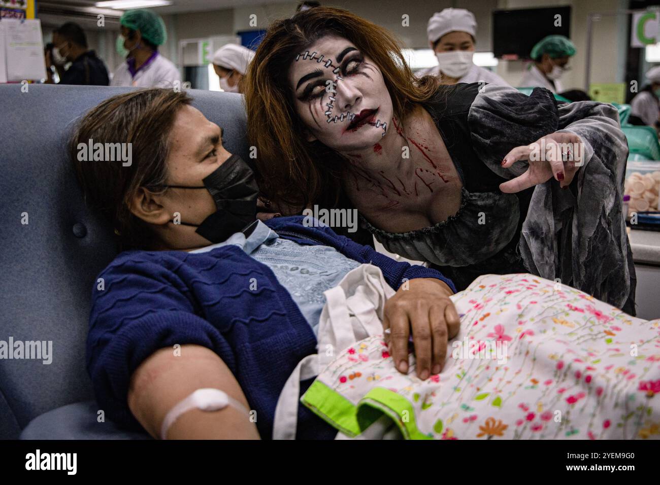 Bangkok, Thailand. 31. Oktober 2024. Ein Mitarbeiter in einem Geisterkostüm neckt einen Blutspender während einer Halloween-Blutspendefahrt im National Blood Center, Thai Red Cross Society in Bangkok. (Kreditbild: © Wissarut Weerasopon/ZUMA Press Wire) NUR REDAKTIONELLE VERWENDUNG! Nicht für kommerzielle ZWECKE! Stockfoto