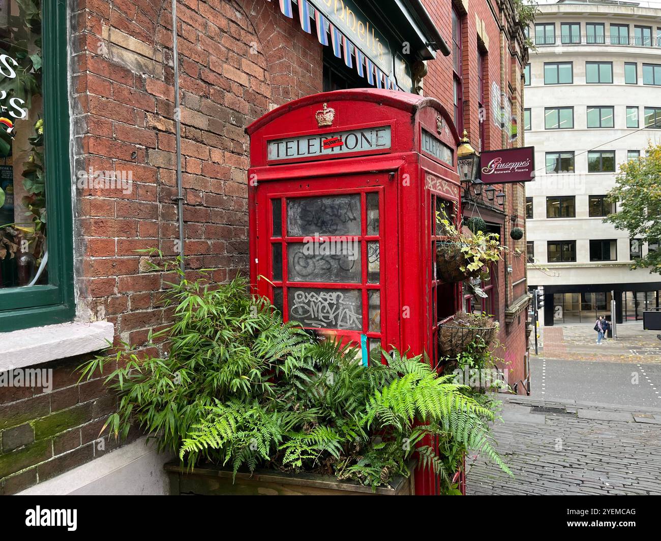 Eine britische rote Telefonbox vor der irischen Bar von Seamus O'Donnells. Bristol, England, Vereinigtes Königreich. Oktober 2024. - Smartphone-aufgenommenes Stockfoto