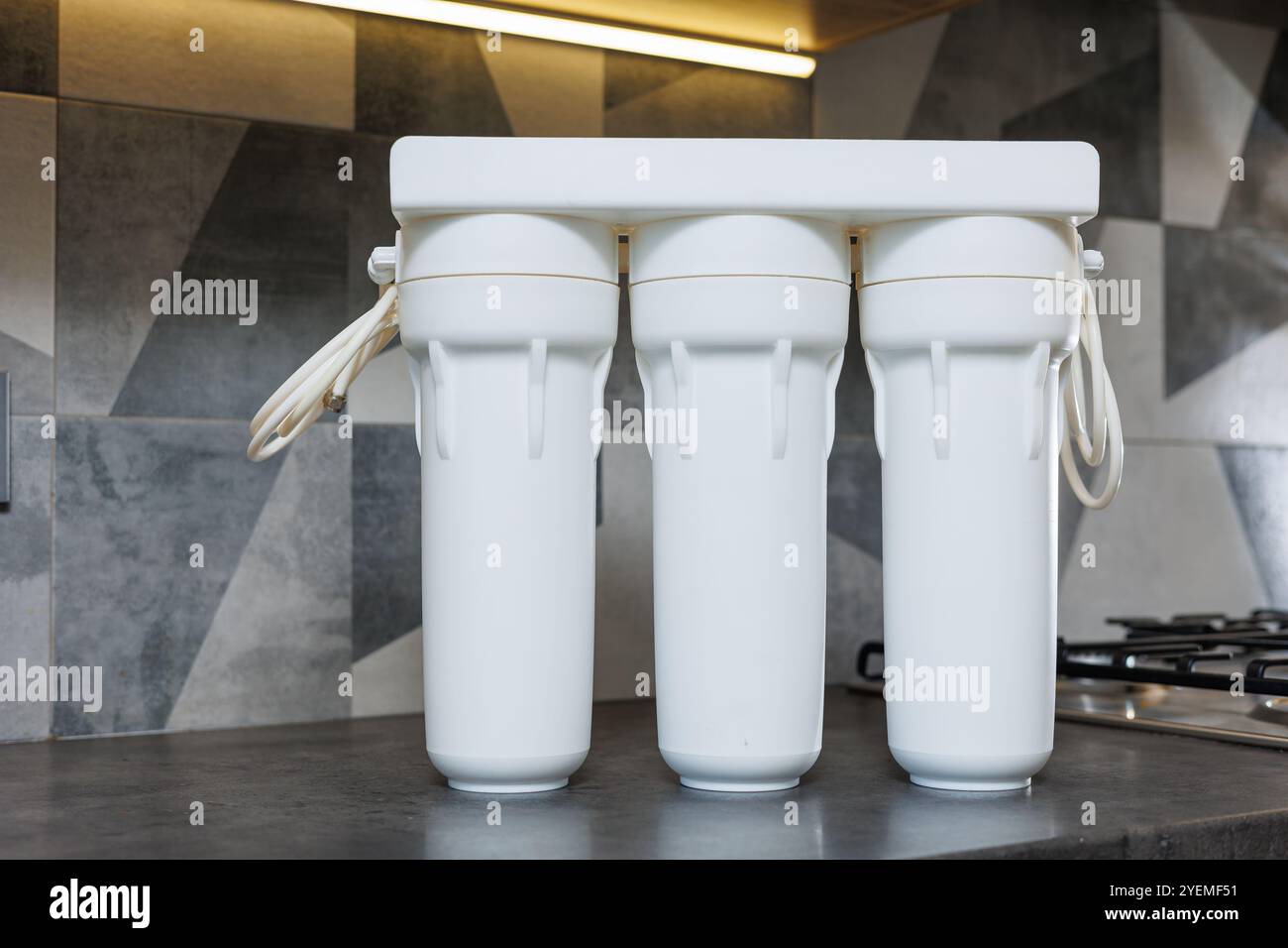 Wasserfiltersystem mit austauschbaren Kartuschen. Ein System in einer Wohnung mit drei Tanks zur Reinigung von Wasser unter dem Wasserhahn. Stockfoto