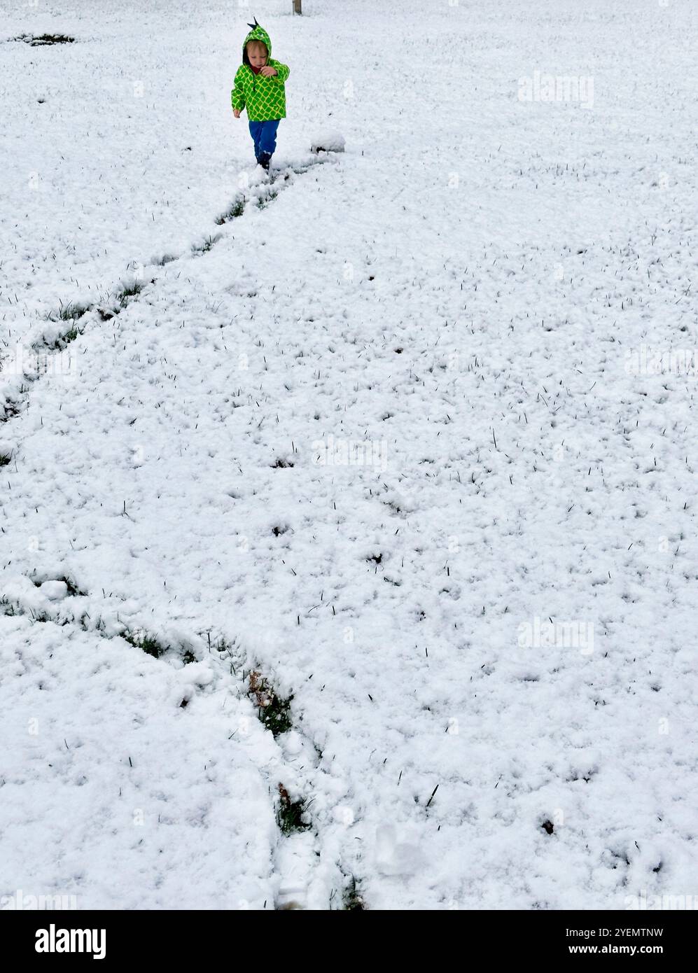Junge, der im Schnee im Park Spuren hinterlässt, Michigan, USA - Smartphone-aufgenommenes Stockfoto