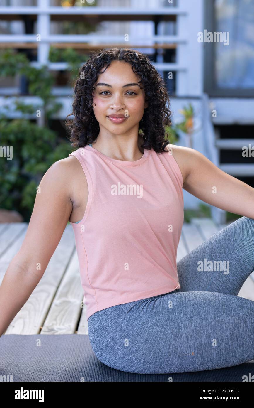 Lächelnde Frau, die Yoga an Deck übt, genießt eine friedliche Umgebung im Freien. Meditation, Wellness, Fitness, Entspannung, Ruhe, Übung Stockfoto