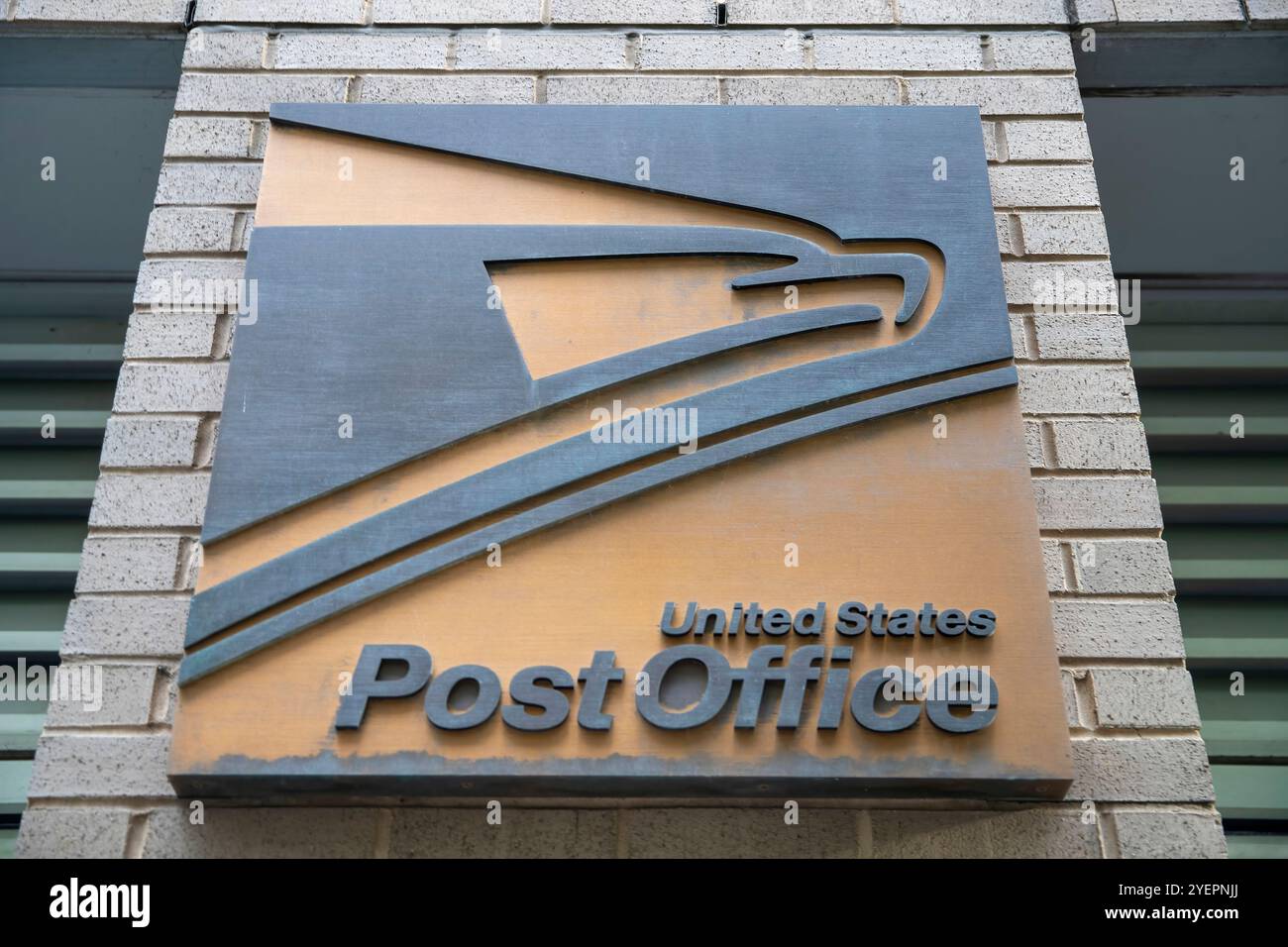 Dieses Bild zeigt das USPS-Logo (United States Postal Service) auf der Außenseite eines Postgebäudes mit dem ikonischen Adlersymbol. Stockfoto