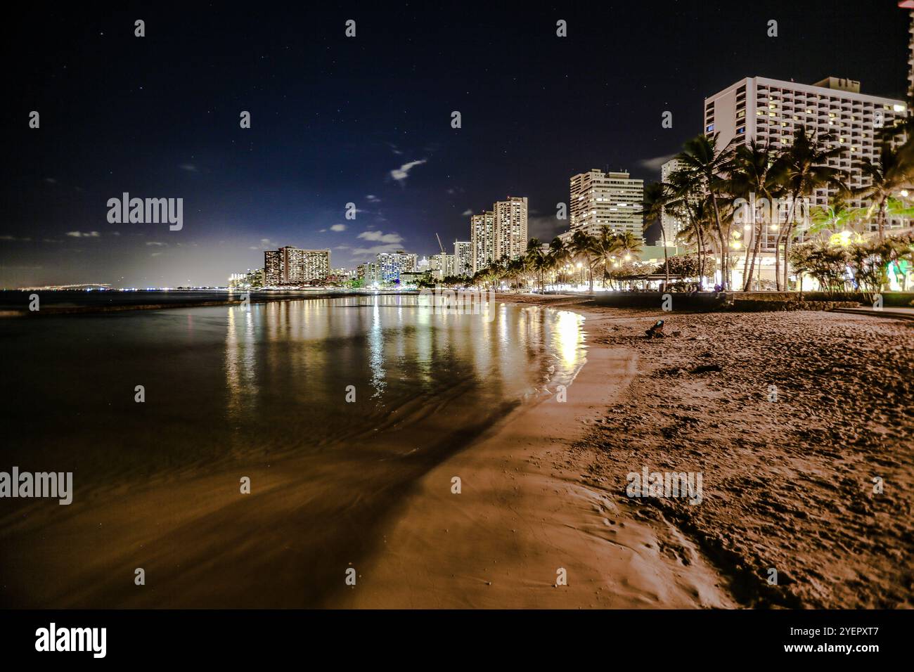 Waikiki Beach bei Nacht mit Straßenlaternen und Nachthimmel Stockfoto