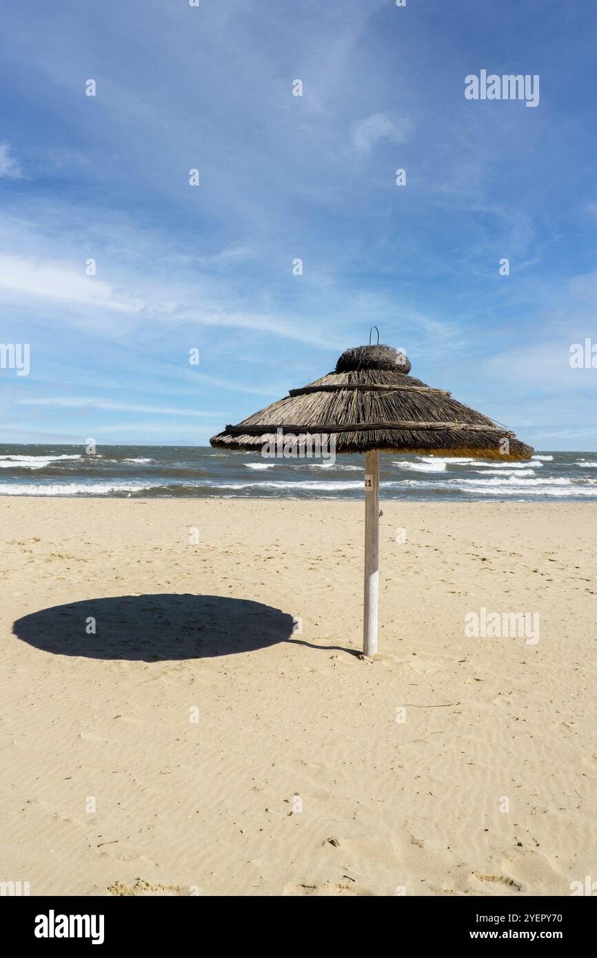 Strohstrand Rattanschirm am leeren Strand mit blauem Himmel Hintergründe Meer Ozean Küste. Entspannender Tag. Kopieren Sie Platz für Ihren Text. Idyllisches Reisen und Su Stockfoto