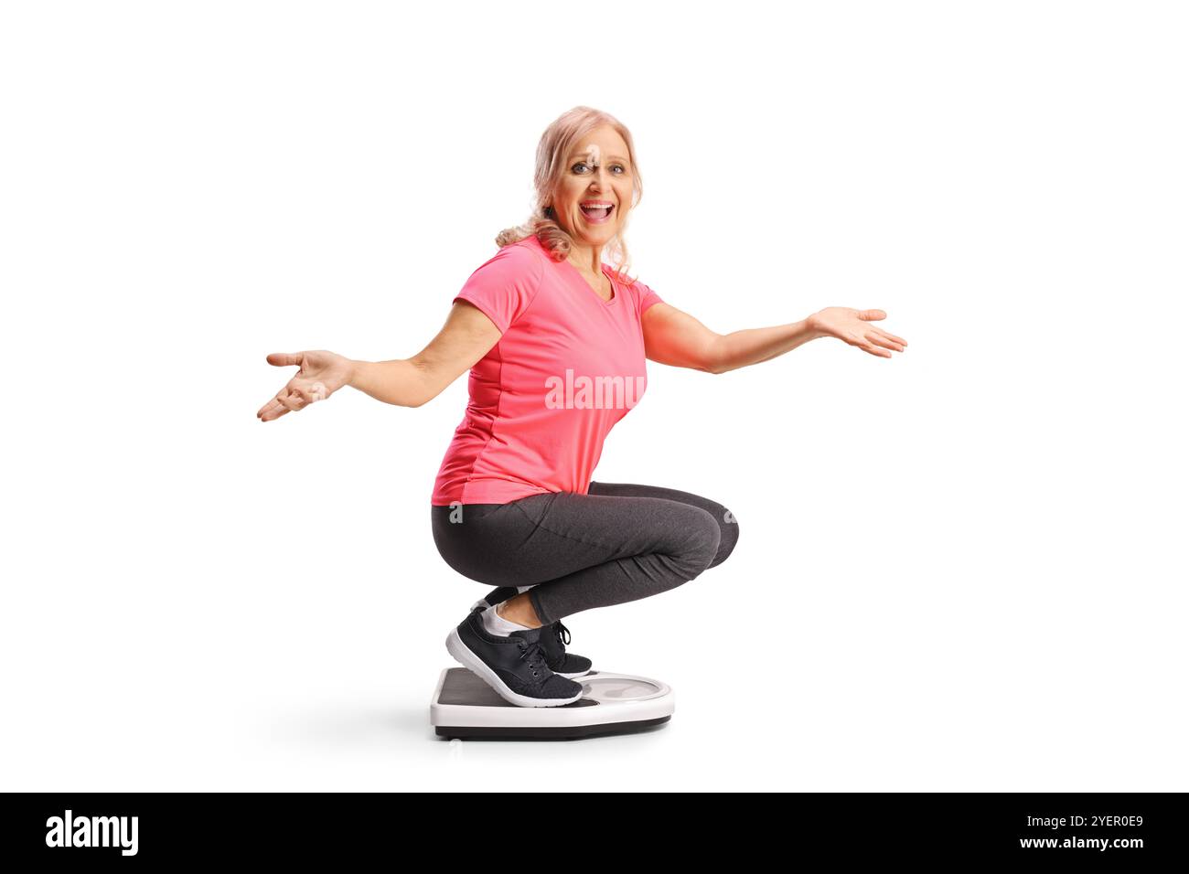 Glückliche reife Frau, die auf einer Waage wiegt, Gewichtsreduktion Konzept isoliert auf weißem Hintergrund Stockfoto