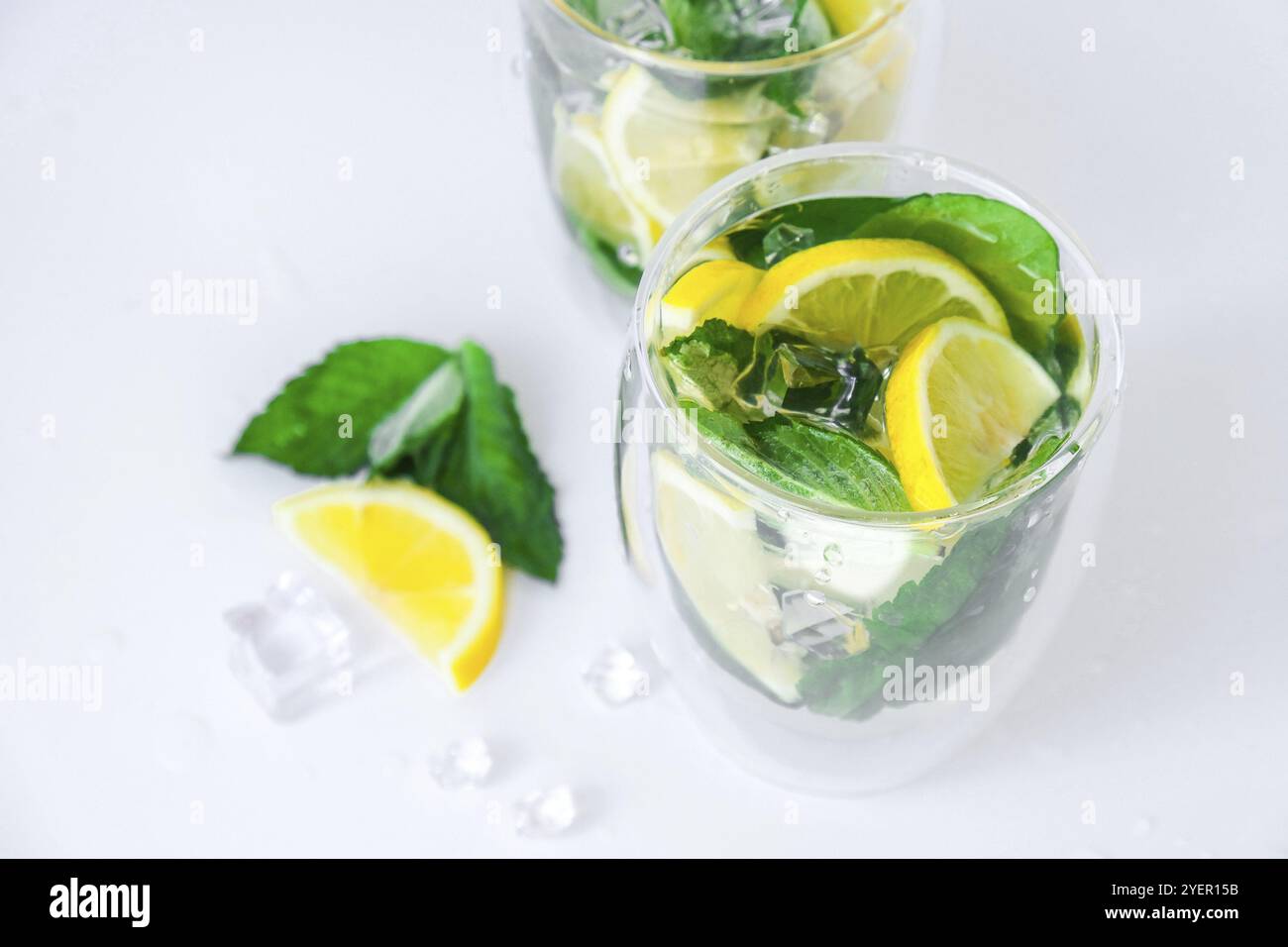 Erfrischender Mojito-Cocktail, Alkoholgetränk. Limonade mit Zitronen- und Minzblättern auf hellem Hintergrund. Eiswürfel. Erfrischende Detox-Getränke im Sommer. Sauber e Stockfoto