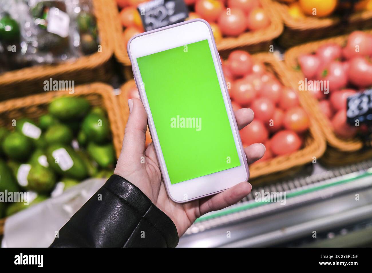 Chroma-Taste. Nahaufnahme der Frau hält Smartphone mit grünem Bildschirm im Supermarkt. Einkaufszentrum. Kaufhaus. Einkaufszentrum. Online einkaufen. Gadgets Stockfoto