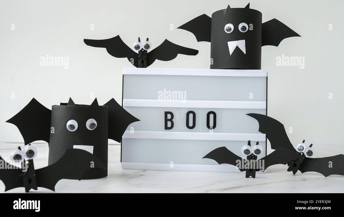 Lightbox mit Text BOO um Papierfledermäuse. Halloween Party Dekoration. Grußkarte für Herbsturlaub oder Trick Stockfoto