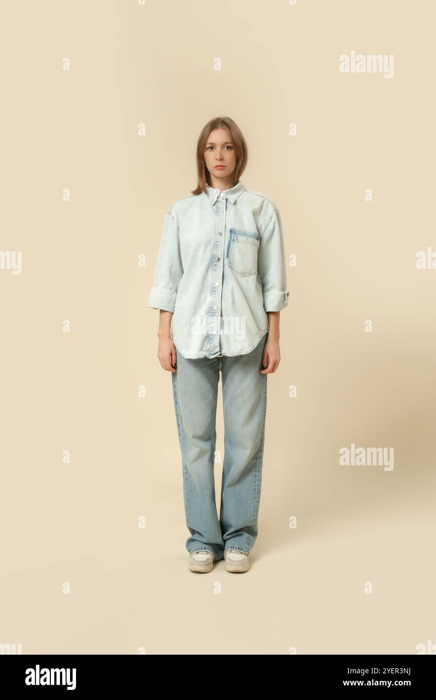 Serie von Studiofotos von Frauen in modernem, legeren Outfit, blauer Jeans, weißem Tanktop und Denim-Overshirt. Stockfoto