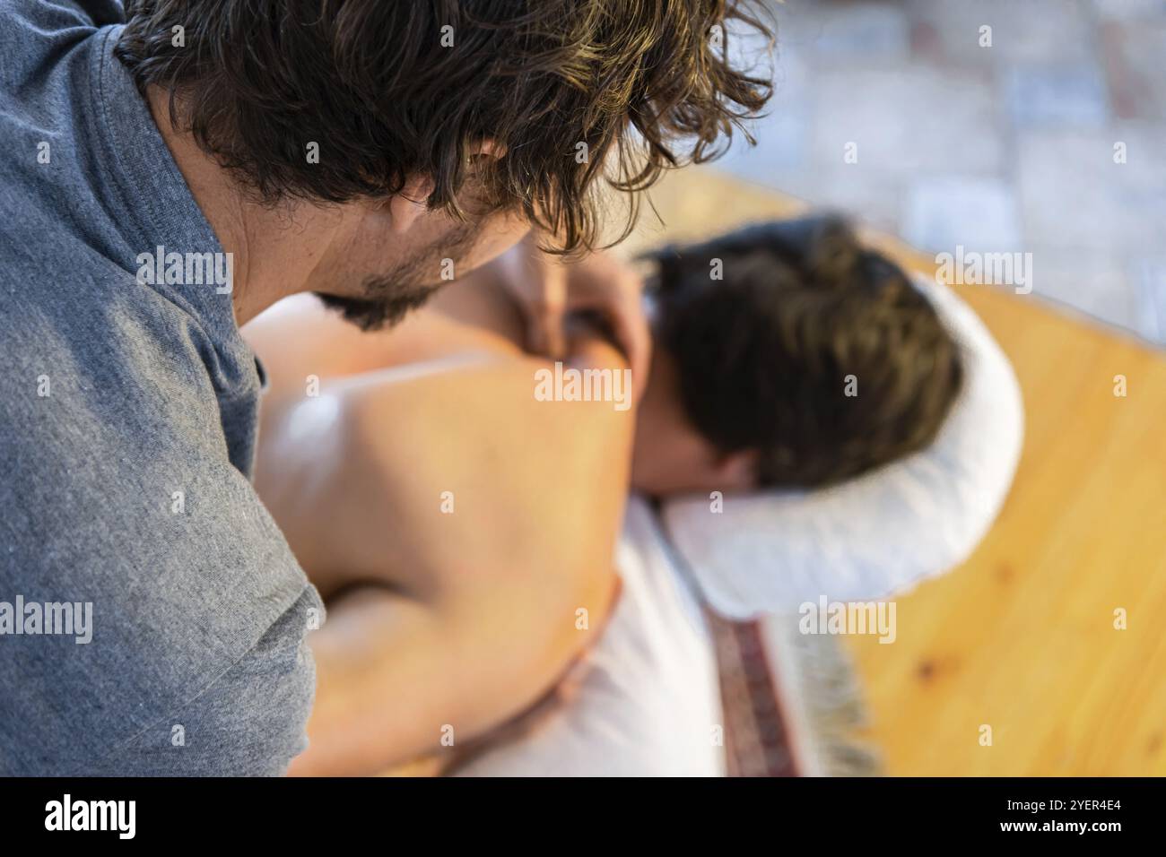 Junger Mann mit entspannender Rücken- und Nackenmassage. Masseur-Therapeut massiert die Wunde am Rücken des Patienten medizinisch. Ansicht von oben Stockfoto
