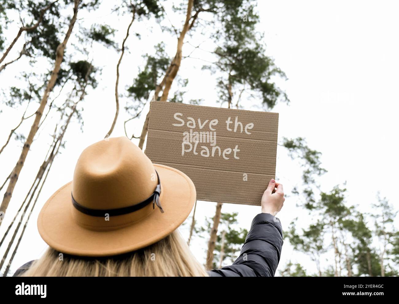 Weibliche Hände, die Pappe mit Text HALTEN, RETTEN DEN PLANETEN im Freien. Natur Hintergrund. Protestantischer Aktivist. Sozialer Aktivismus Stockfoto