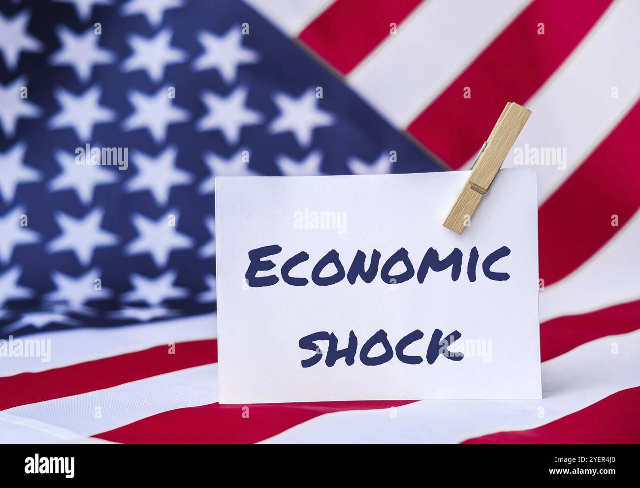 Die Nationalflagge der USA. Amerikanischer Flaggen- und Papiertext: ÖKONOMISCHER SCHOCK. Globaler Hunger, Inflation, hohe Preise, steigende Lebenshaltungskosten Stockfoto