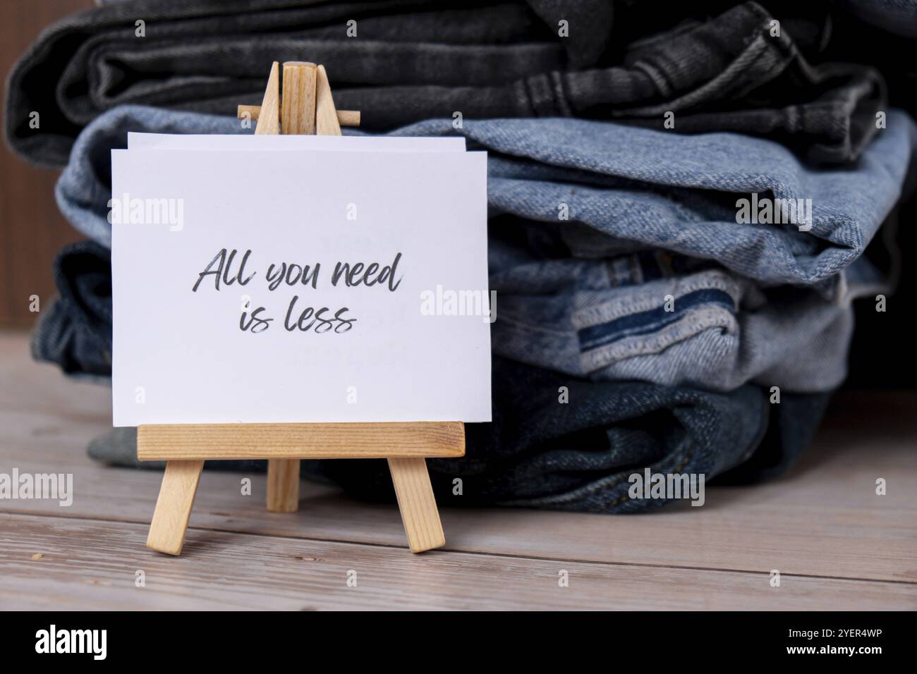 ALLES, WAS SIE BRAUCHEN, IST WENIGER Text auf Papiernotizen zu Jeans Kleidung Sortiment Second Hand nachhaltiges Einkaufen. Capsule Minimal Garderobe. Nachhaltige Mode ov Stockfoto