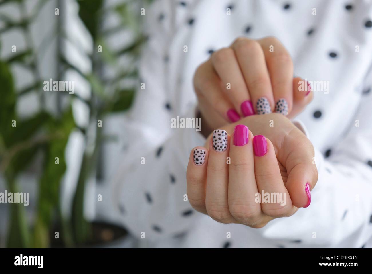 Gepflegte weibliche Hände mit stilvollen rosa Nägeln und Design. Trendige Maniküre in modernem Design. Gelnägel. Hautpflege. Schönheitsbehandlung. Nagelpflege. Wellness. Stockfoto