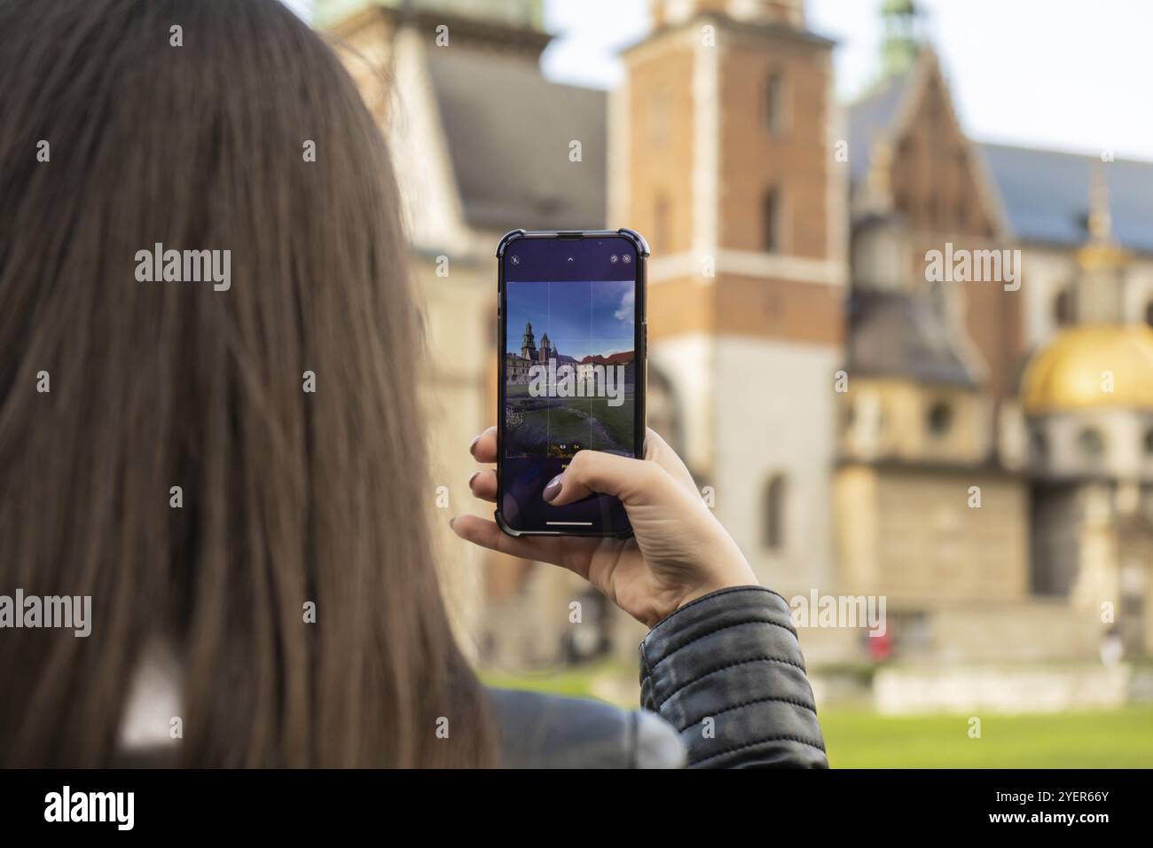 Eine Reisende Frau an historischen Orten schaut sich den Innenhof des Wahrzeichens an und macht kurze Videoaufnahmen am Telefon. Touristische Fotografien historischer Ort auf sonnigem d Stockfoto