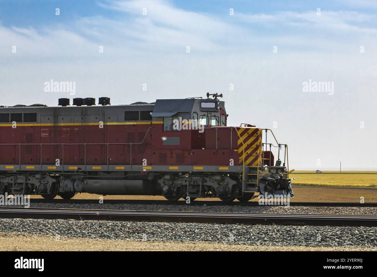 Oldtimer-Lokomotive eines alten Güterzuges der Canadian National Railways, rot mit gelben Streifen. Auf dem Land in Richtung rechts Stockfoto