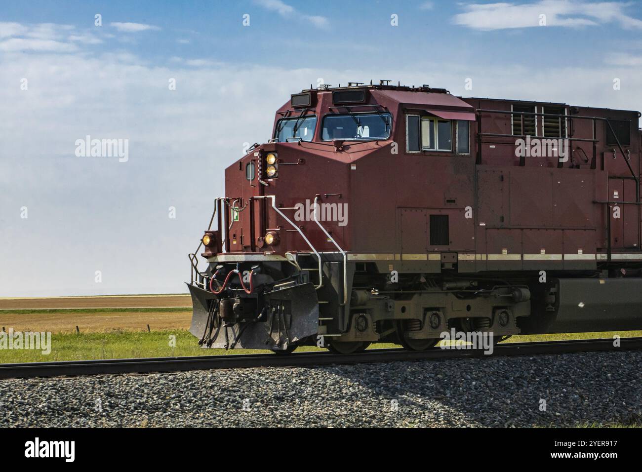 Oldtimer-Lokomotive eines roten Güterzuges der Canadian National Railways mit eingeschalteten Scheinwerfern, die sich nach links bewegen. Kopierbereich links Stockfoto