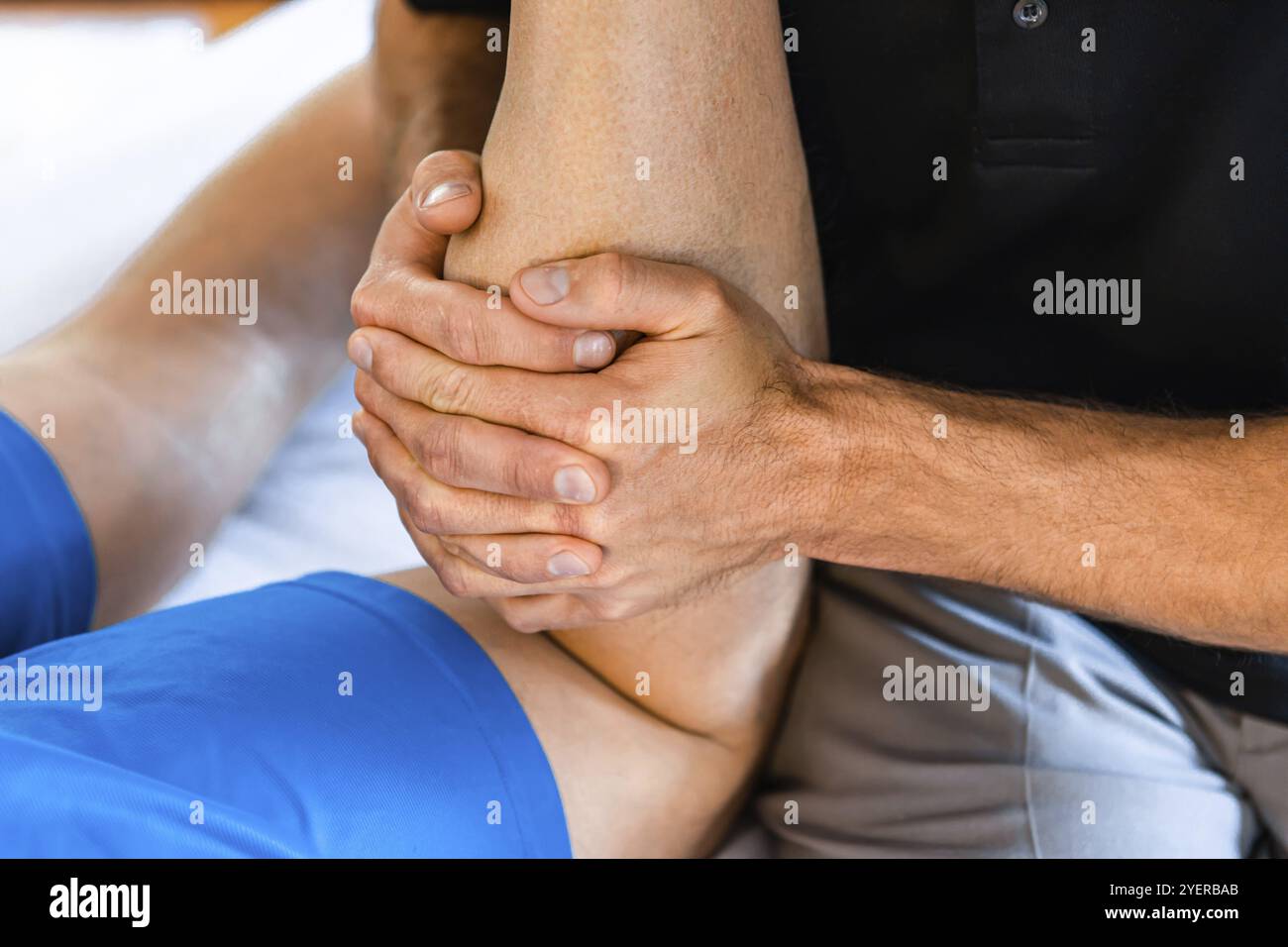 Ein nicht erkennbarer Profi-Sportmasseur, der nach einer Verletzung an Sportbeinen arbeitet. Konzepte zur Rehabilitation von Osteopathie und Sportverletzungen Stockfoto