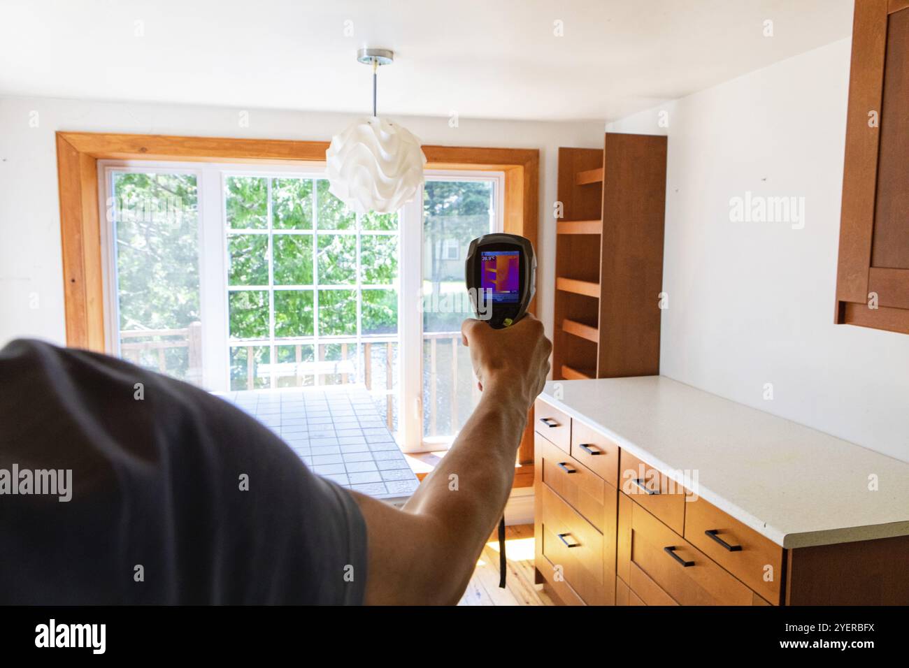 Ein Übersichtspunkt eines IEQ-Sachverständigen in Innenräumen bei der Arbeit in einer Küche mit einem Wärmebildgerät zur Überprüfung der Heimatregion Stockfoto