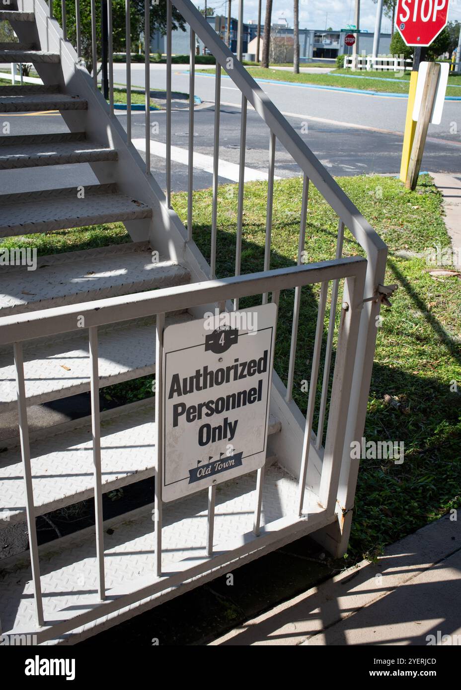 Autorisiertes Personal unterschreibt nur auf einer Metalltreppe in Old Town, Kissimmee in Florida, USA Oktober 2024 mit einem Straßenschild und einem Stoppschild dahinter - No People Stockfoto