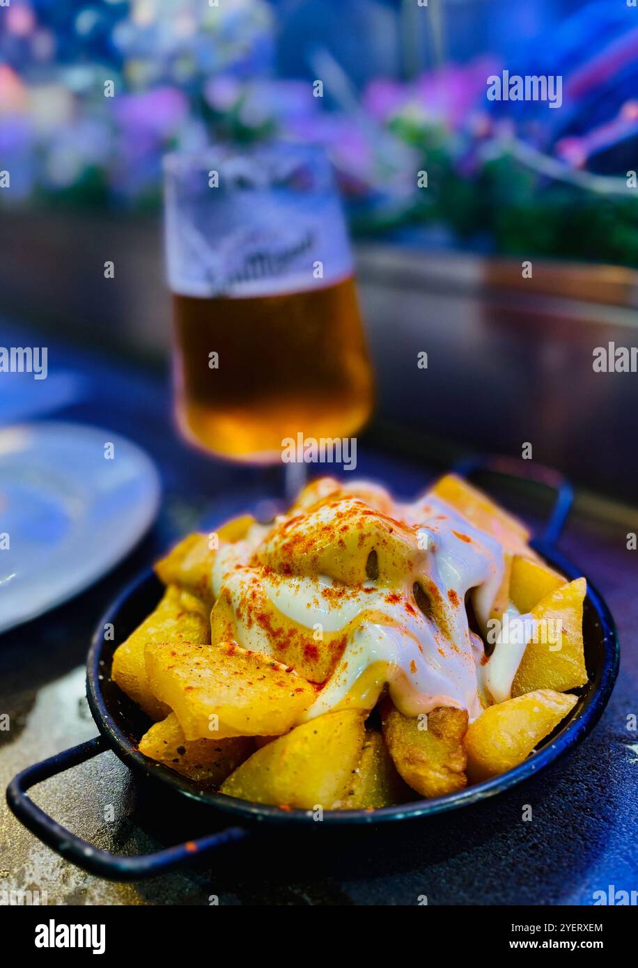 San Miguel Bier vom Fass mit Papaten Bravas in einer Tapas Bar im Mercat de la Boqueria in Barcelona, Spanien. Stockfoto