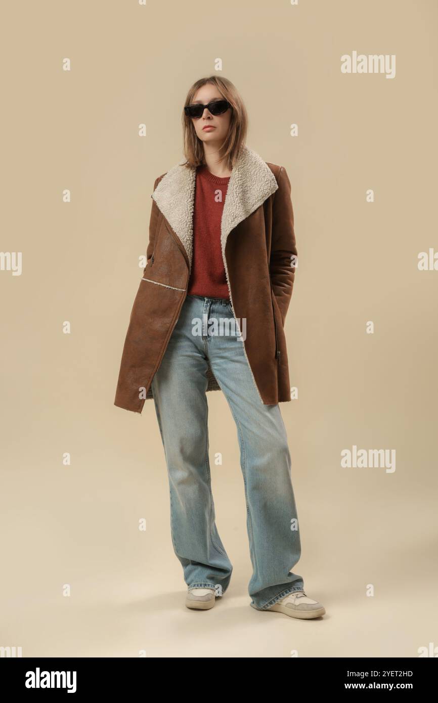 Serie von Studiofotos von Frauen im klassischen Herbst-Winter-Outfit – blaue Jeans und Winterjacke aus Schafsleder Stockfoto