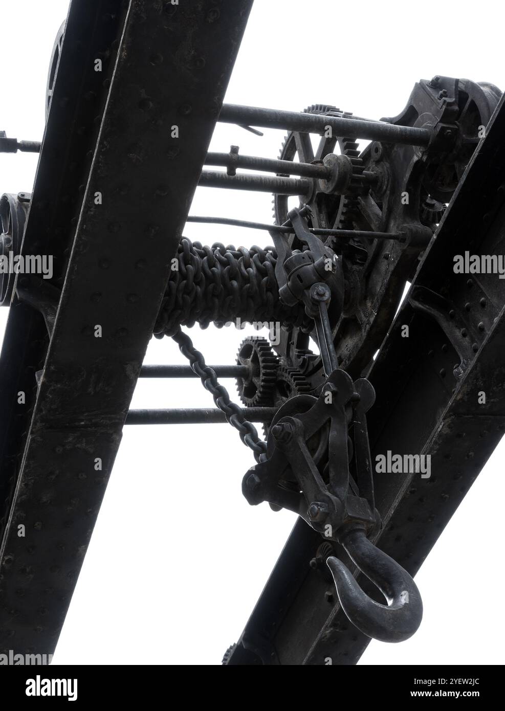 Alte Krandetails isoliert auf weißem Hintergrund. Massive schwarze Zahnräder und andere Teile von Vintage-Industriemaschinen, Schwarzweißfoto, abstraktes Hea Stockfoto