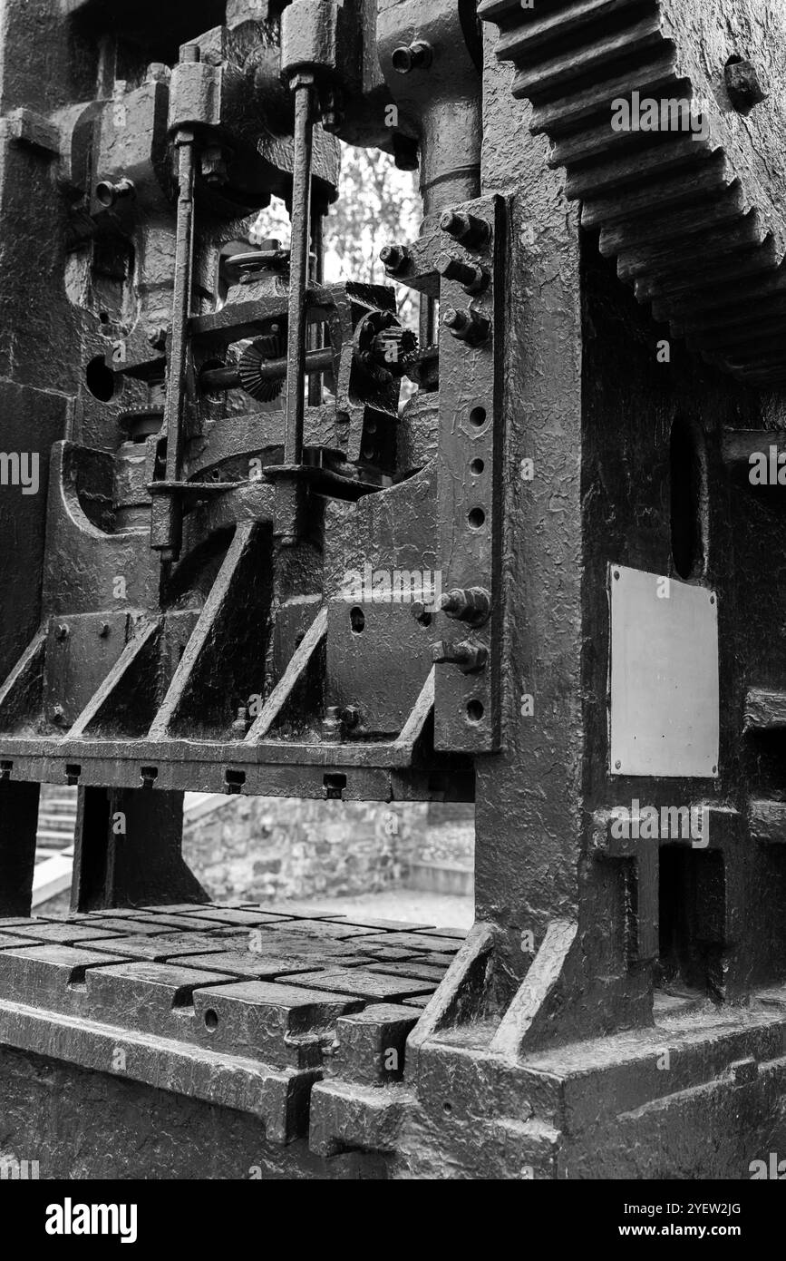 Doppelkurbel drücken. Massive schwarze Getriebe und andere Teile von Vintage-Industriemaschinen, Nahaufnahme Schwarzweiß-Foto mit selektivem Fokus, schwere Indu Stockfoto