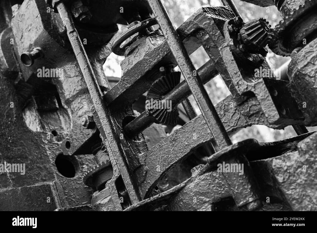 Massive schwarze Zahnräder und andere Teile von Vintage-Industriemaschinen, Nahaufnahme Schwarzweiß-Foto mit selektivem Fokus, schwerer Industriehintergrund mit Stockfoto