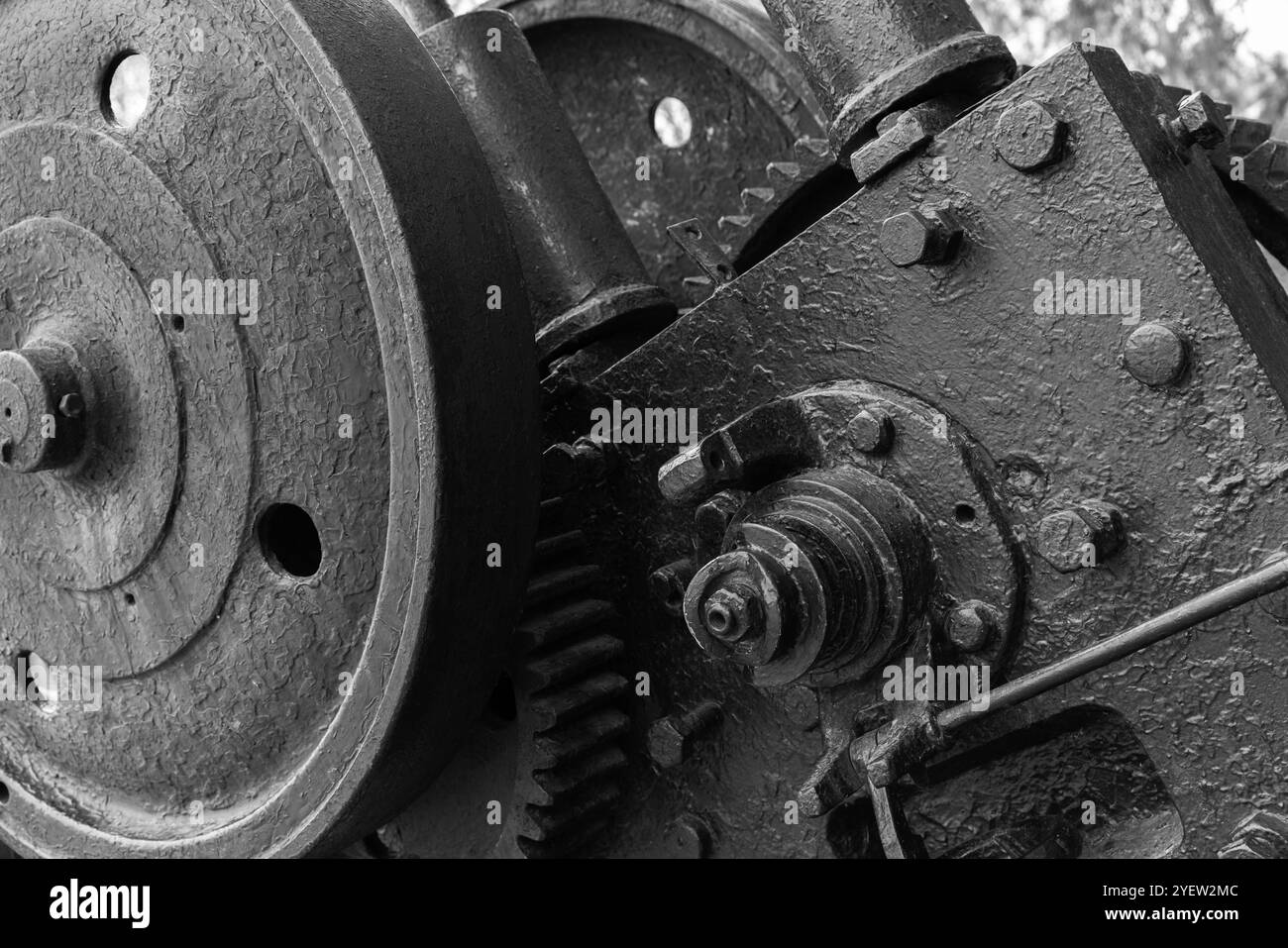 Zahnräder und andere Teile von Vintage-schwarzen Industriemaschinen, Nahaufnahme Schwarzweiß-Foto mit selektivem Fokus, abstrakter Hintergrund der Schwerindustrie Stockfoto