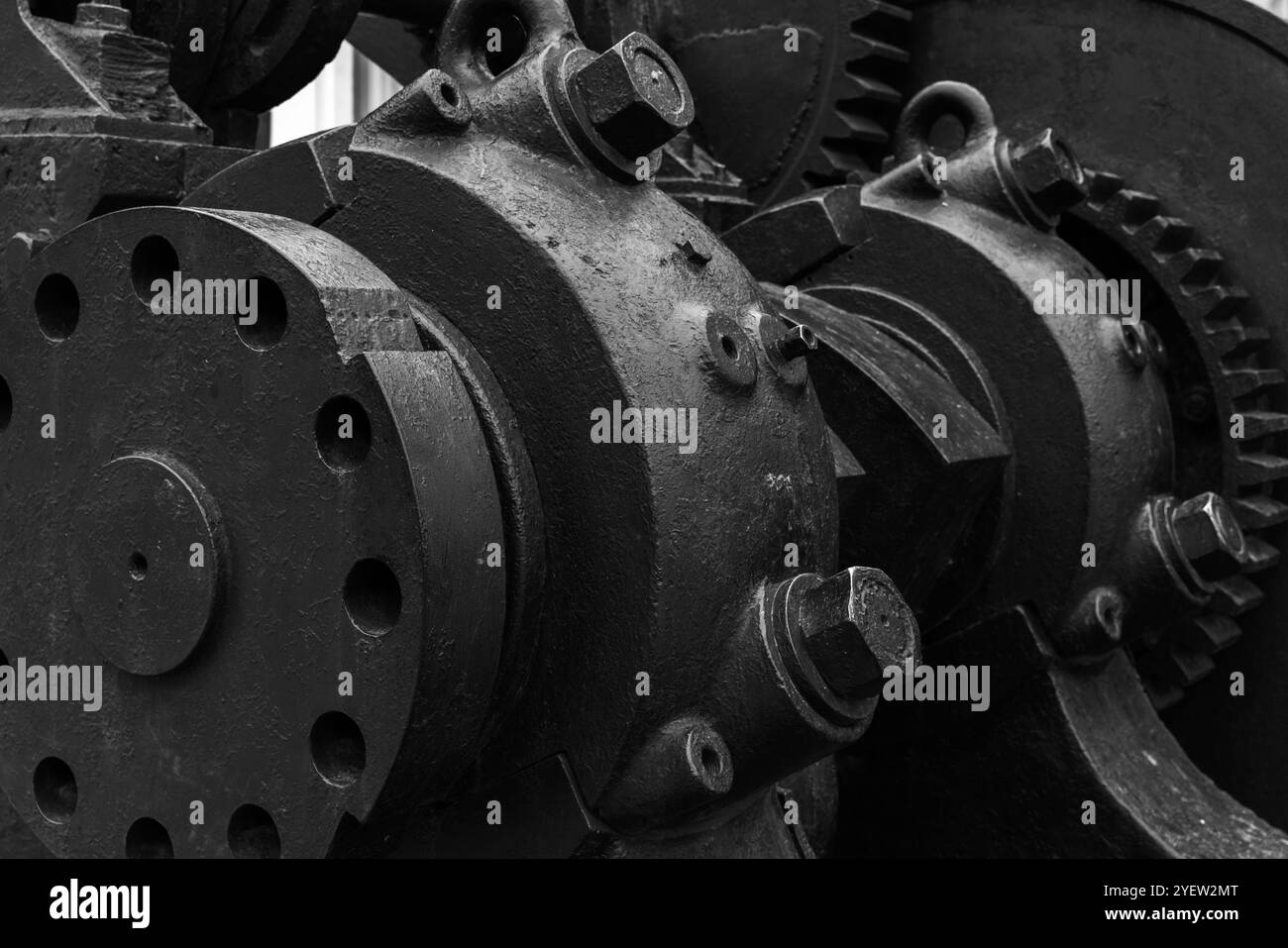 Massive Zahnräder und andere Teile der schwarzen Vintage-Industriemaschine, Nahaufnahme Schwarzweiß-Foto mit selektivem Fokus, abstrakter Hintergrund der Schwerindustrie Stockfoto