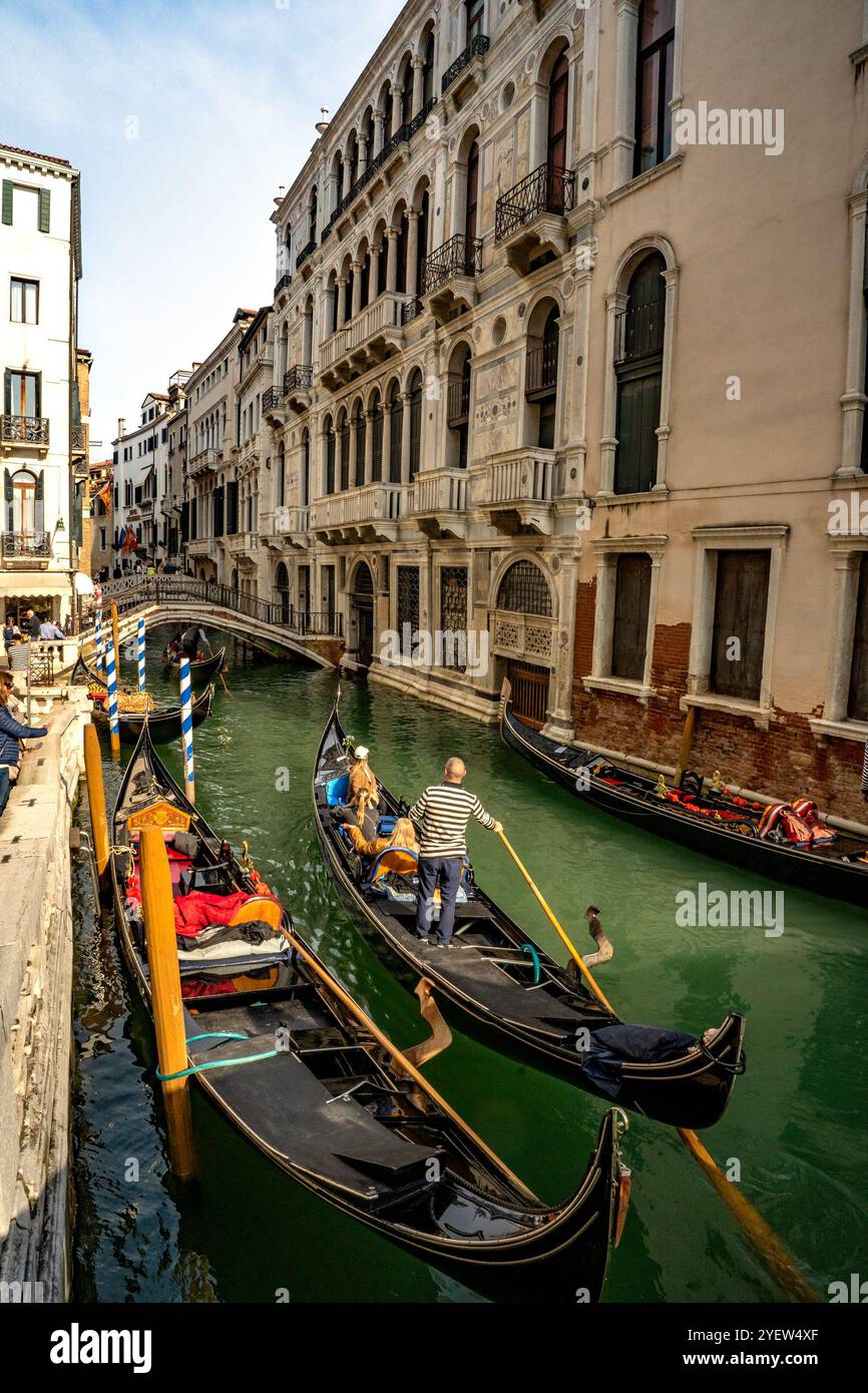 Venedig, Vento – IT – 13. Oktober 2024 Eine venezianische Gondel gleitet sanft durch enge Kanäle, unter alten Steinbrücken, vorbei an großen Palazzen. Das Boot Stockfoto