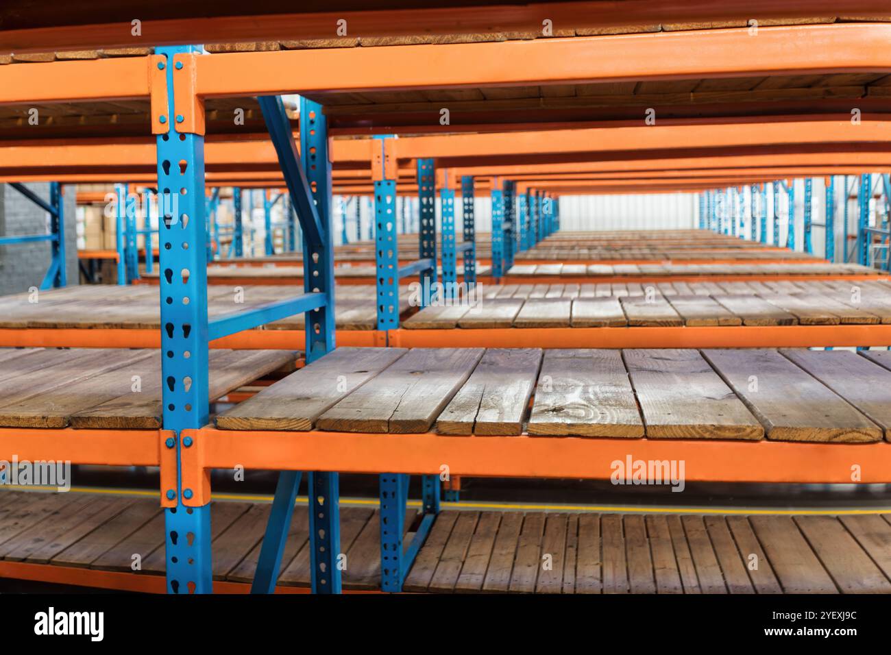 Robuste Industrieregale mit Holzdielen blau und orange Stockfoto