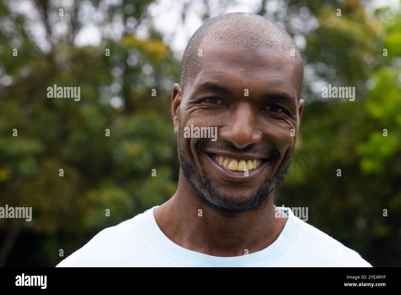 Ein lächelnder afroamerikanischer Mann genießt die Natur im Freien, fühlt sich glücklich und entspannt im Park Stockfoto