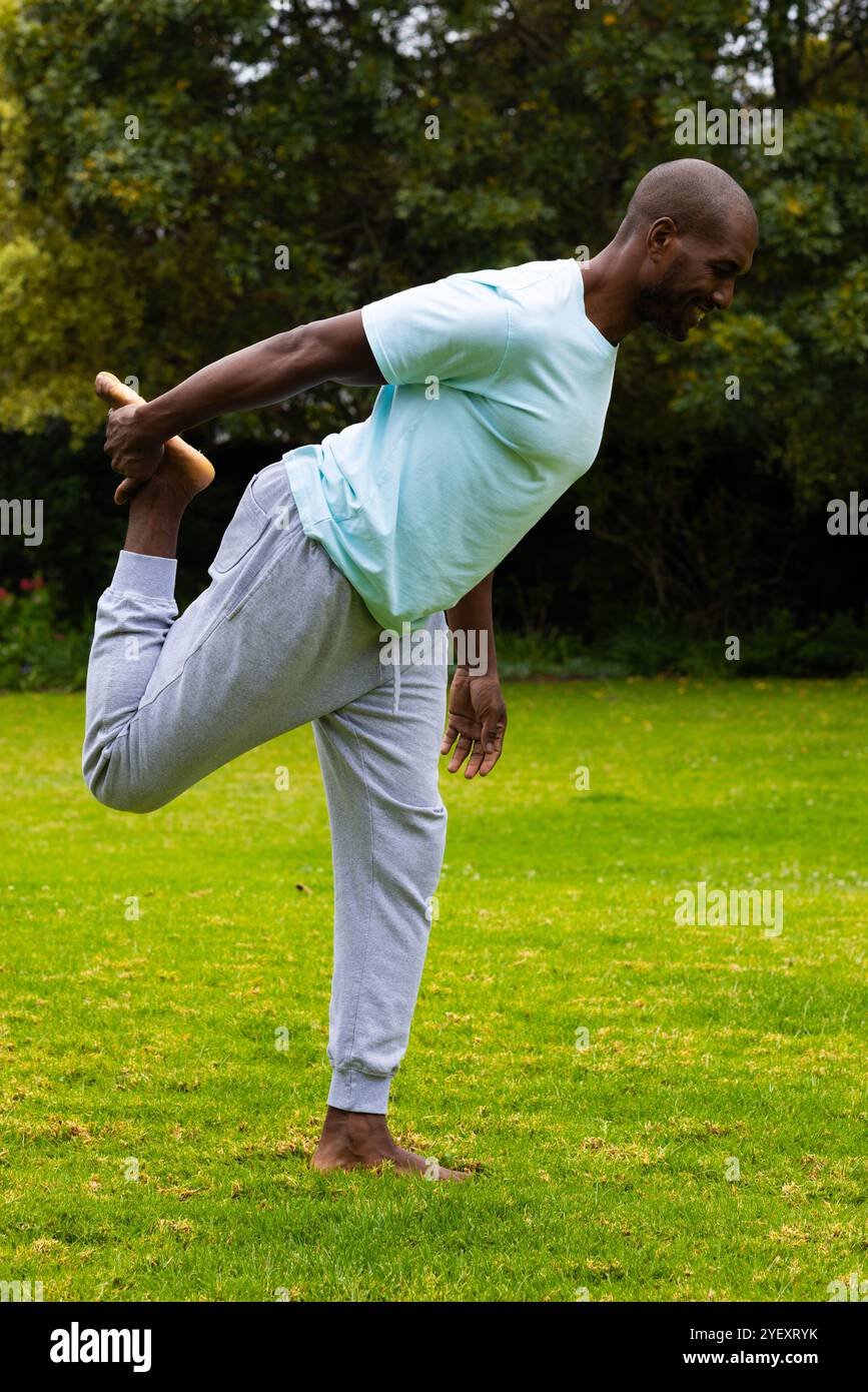 afroamerikanischer Mann, der im Park ein Bein streckt, Outdoor-Training und frische Luft genießt Stockfoto