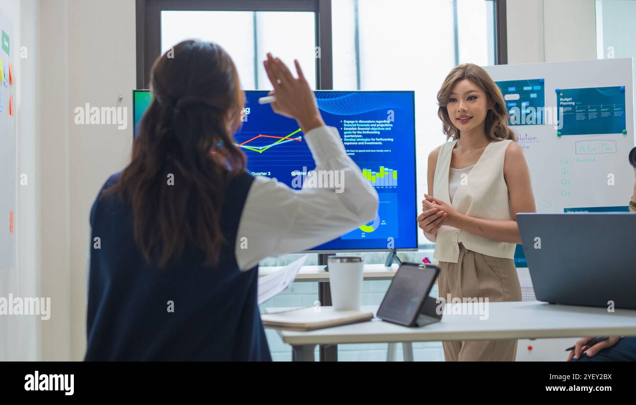 Finanzfragen, wenn der Vorgesetzte Daten während eines nächtlichen Meetings überprüft, werden Finanzprognosen und digitale Berichte auf einem Bildschirm angezeigt Stockfoto