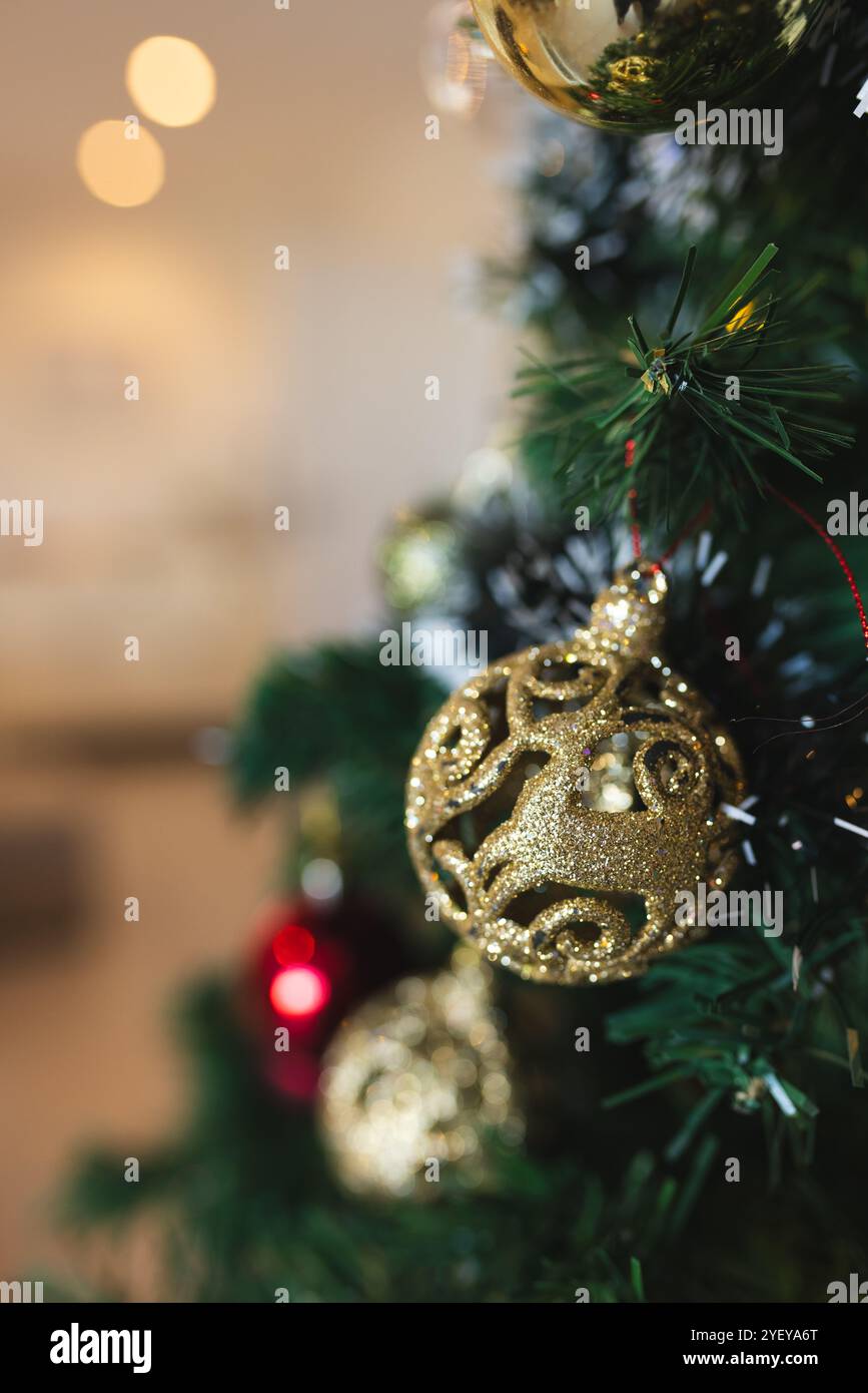 Die Dekoration des Weihnachtsbaums mit goldenen Ornamenten sorgt für festliche Feiertagsatmosphäre zu Hause Stockfoto