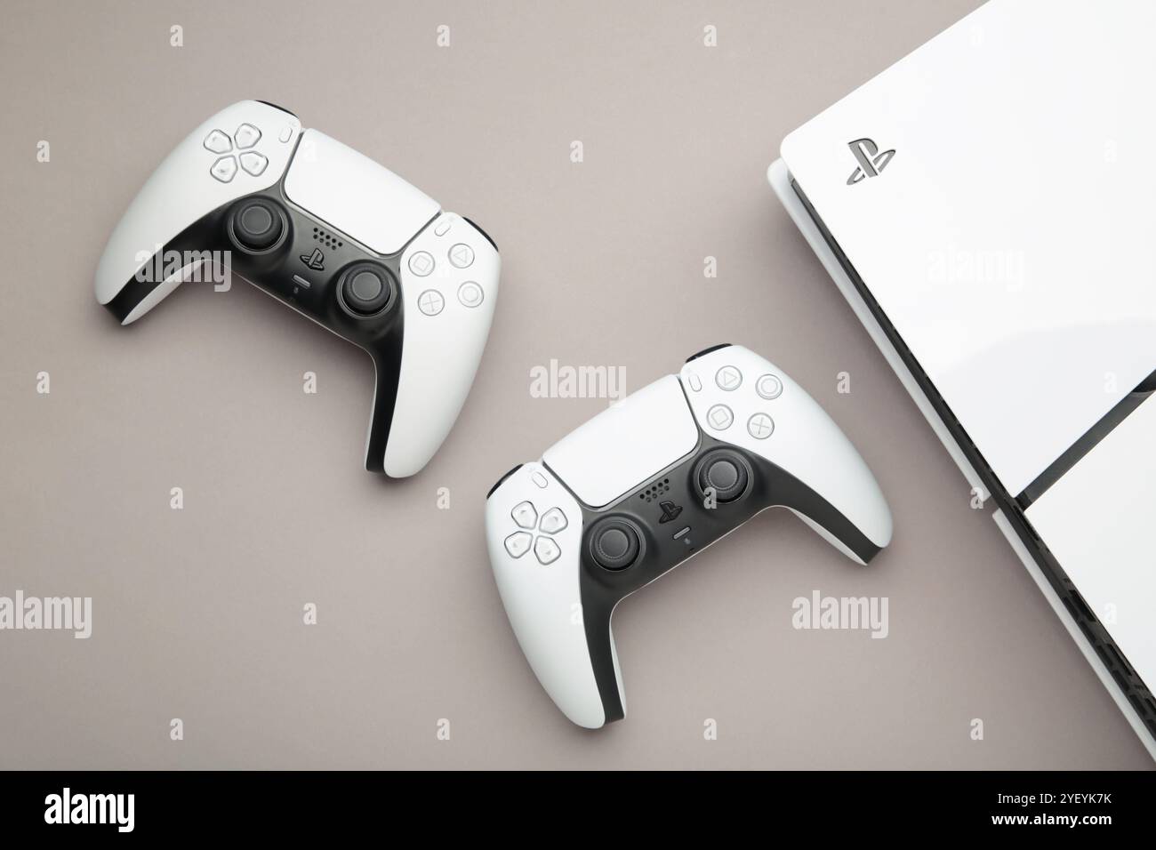 Mykolaiv, UKRAINE - Juli 2024: Weiße Konsole, PlayStation 5 und Gamepad auf grauem Hintergrund Stockfoto