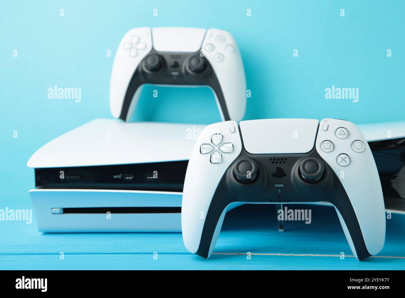 Mykolaiv, UKRAINE - Juli 2024: Weiße Konsole PlayStation 5 und Gamepad auf blauem Hintergrund Stockfoto