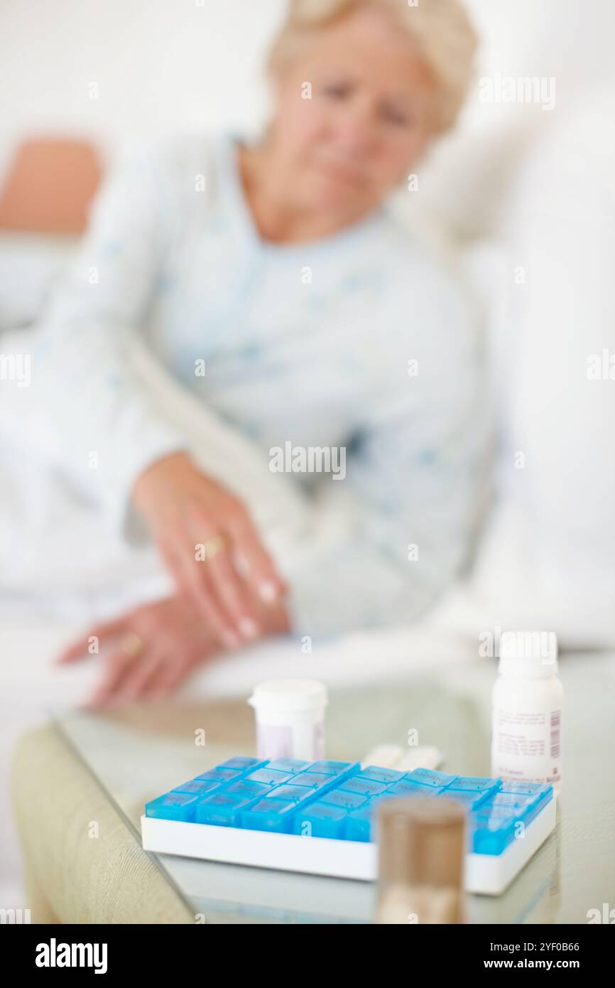 Seniorin, Frau und Tisch mit Medikamenten im Bett zur Morgendosierung, Routine- oder Tagesmedikamente für alzheimer zu Hause. Ältere Menschen, weibliche oder alte Patienten Stockfoto