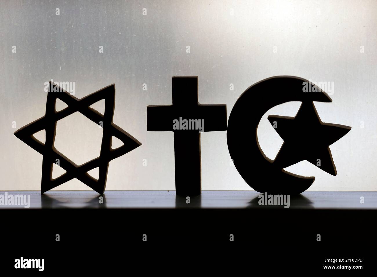 Christentum, Islam und Judaismus : die drei monotheistischen Religionen. Jüdischer Stern, christliches Kreuz und muslimischer Halbmond. Stockfoto