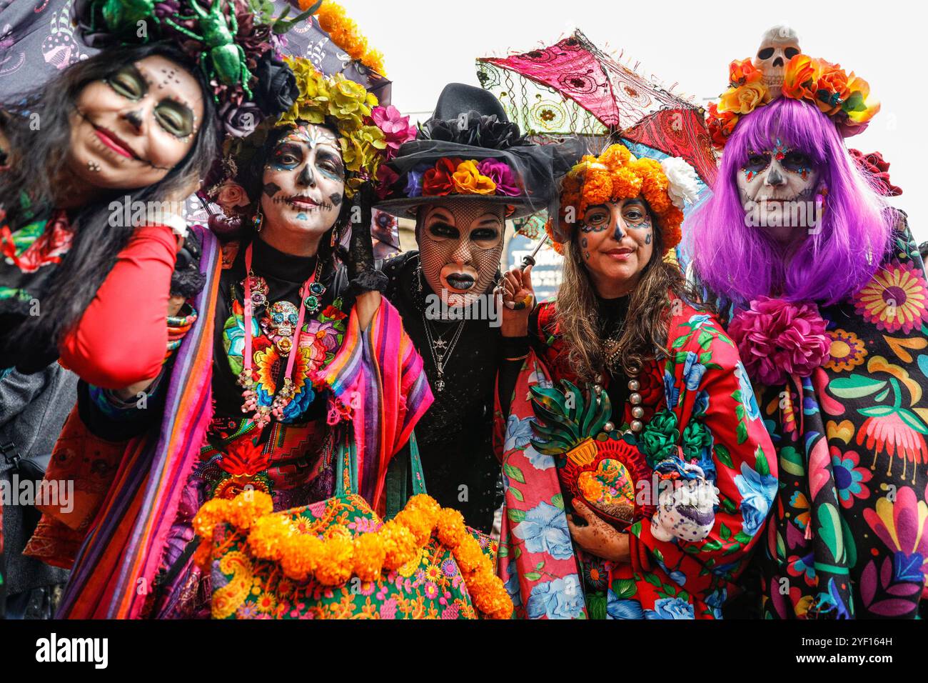 London, Großbritannien. November 2024. Die Teilnehmer, viele in lebendigen Gesichtsbemalungen und Kostümen, versammeln sich in der Columbia Road. Der jährliche Tag der Toten und die Parade auf und um die Columbia Road in grüßt den mexikanischen Tag der Toten, ein freudiger Anlass trotz seines Namens, der das Vergehen geliebter Menschen ehrt. Die Teilnehmer kommen in farbenfrohen Kostümen auf. Quelle: Imageplotter/Alamy Live News Stockfoto