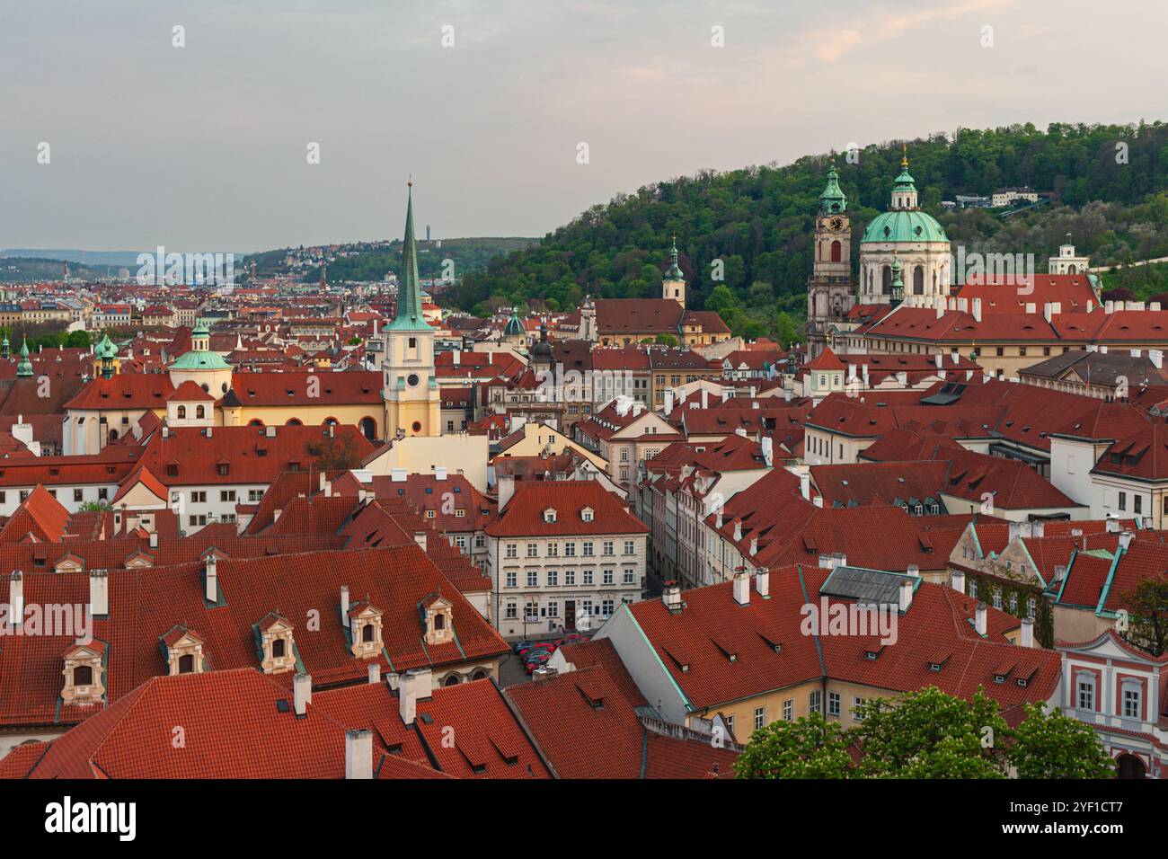 Blick auf die Skyline von Prag in der Abenddämmerung, mit der Thomaskirche auf der linken Seite und der Nikolaikirche (Malá Strana) auf der rechten Seite (Tschechische Republik) Stockfoto