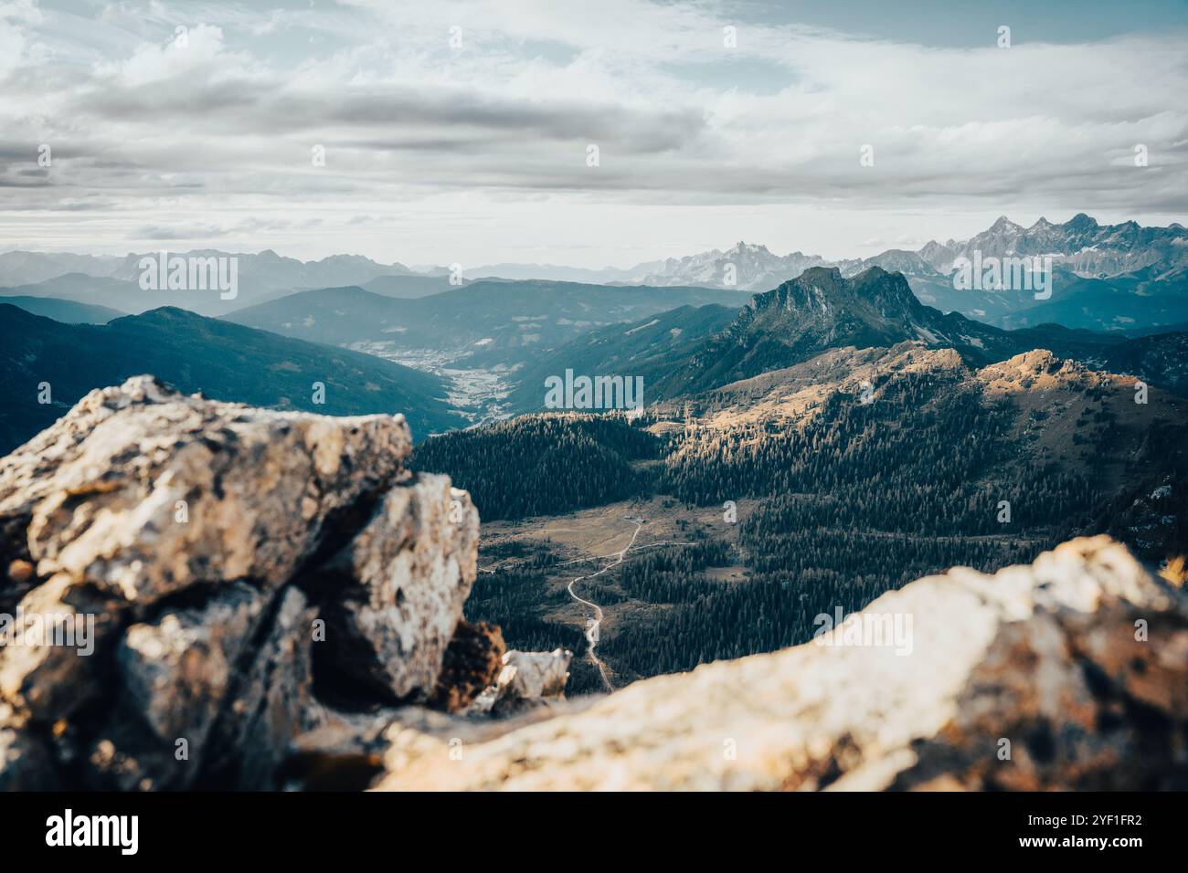 Eine atemberaubende und malerische Aussicht auf eine herrliche Bergkette kann von einer felsigen Klippe aus beobachtet werden, die eine atemberaubende Perspektive bietet Stockfoto