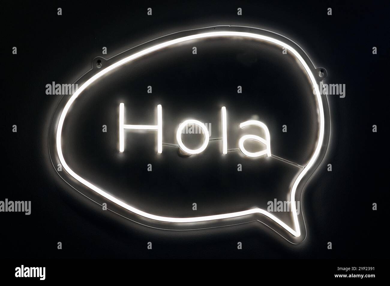 Das Wort „Hello“ ist in weiß in einem Kreis mit schwarzem Hintergrund beleuchtet. Stockfoto