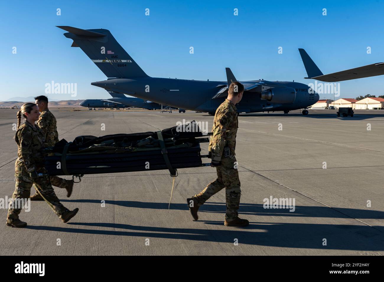 US-Luftstreitkräfte, die der 60th Aeromedical Evakuation Squadron zugeordnet sind, laden Würfe auf eine C-17 Globemaster III der US-Luftwaffe auf der Travis Air Force Base, Kalifornien, 23. Oktober 2024. Die 60. AES bereitete die C-17 darauf vor, Patienten für den medizinischen Transport in verschiedene medizinische Einrichtungen aufzunehmen. (Foto der U.S. Air Force von Senior Airman Lauren Jacoby) Stockfoto