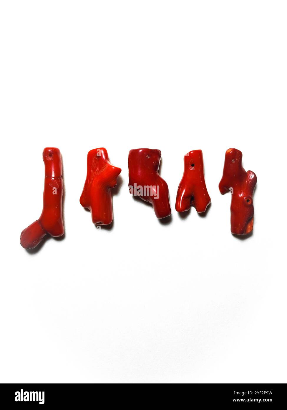 Rote, unregelmäßige Korallenäste aus nächster Nähe. Naturstein, Edelstein, Steinperlen für die Schmuckherstellung isoliert. Rote Korallen auf weißem Hintergrund. Fantastische Naturformen Stockfoto
